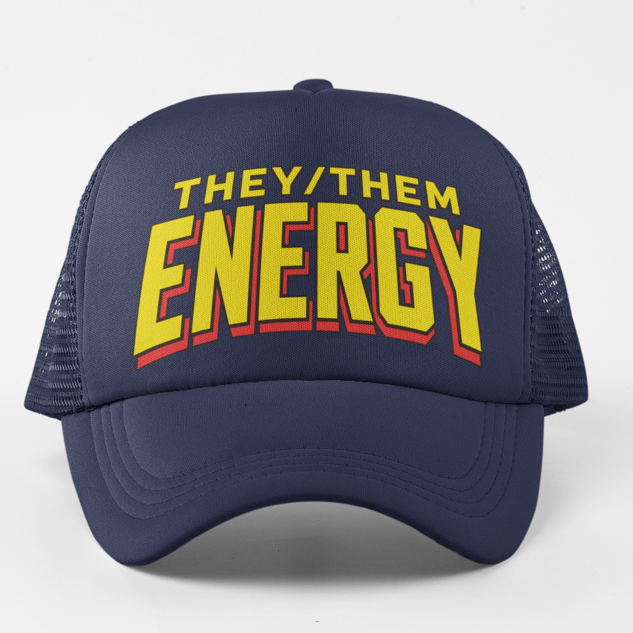 A navy blue trucker hat with a curved brim and mesh back, featuring the text 'THEY/THEM ENERGY' in yellow and red arched lettering on the front, set against a plain light gray background.