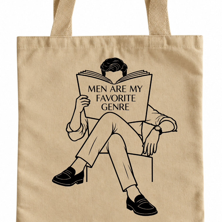 A beige canvas tote bag with a black graphic illustration of a man sitting and reading a book that says 'MEN ARE MY FAVORITE GENRE'.