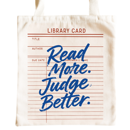 A cream canvas tote bag featuring a library card design with red lines and blue script text that reads 'Read More. Judge Better.